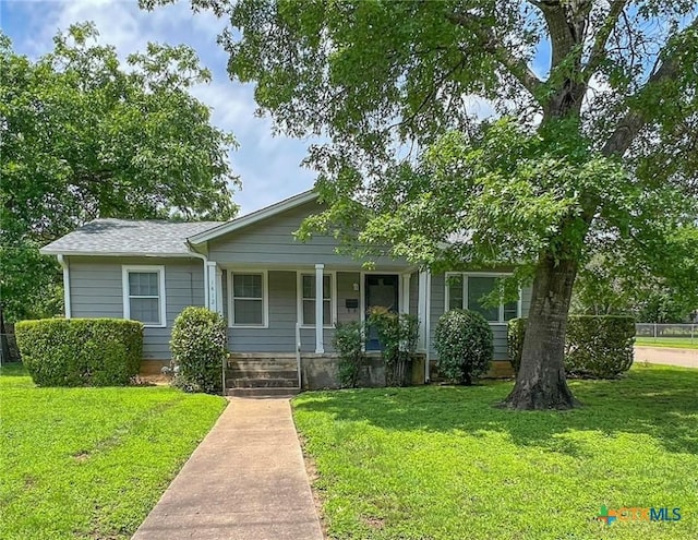 view of front facade featuring covered porch and a front lawn