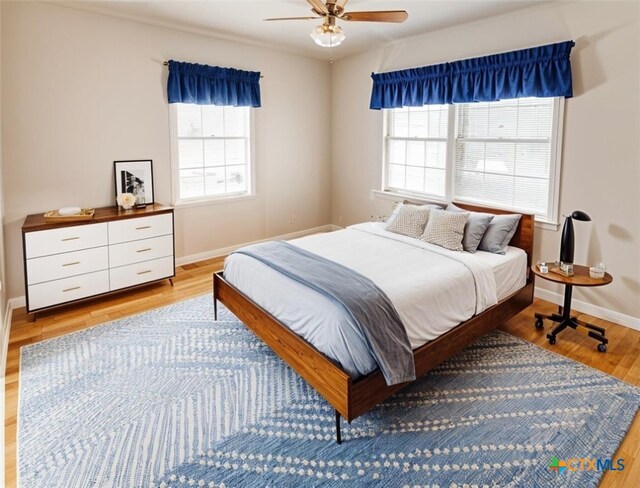 1412 N Beal St, Belton, TX 76513 - bedroom with multiple windows, light wood-style floors, baseboards, and a ceiling fan