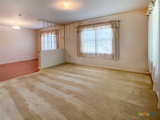 carpeted empty room with baseboards