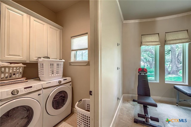 laundry area with ornamental molding, cabinet space, independent washer and dryer, and baseboards