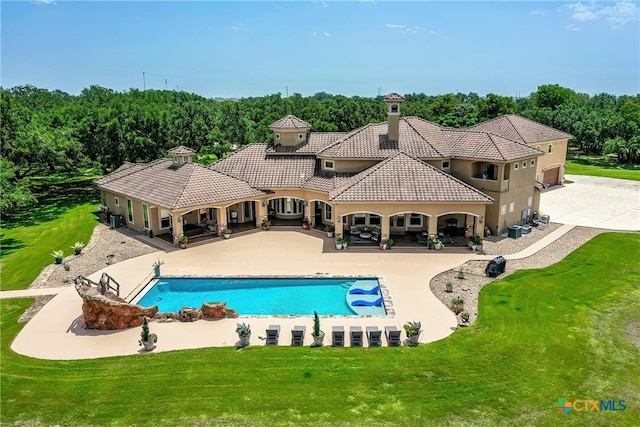 pool with a patio area, central AC unit, and a lawn