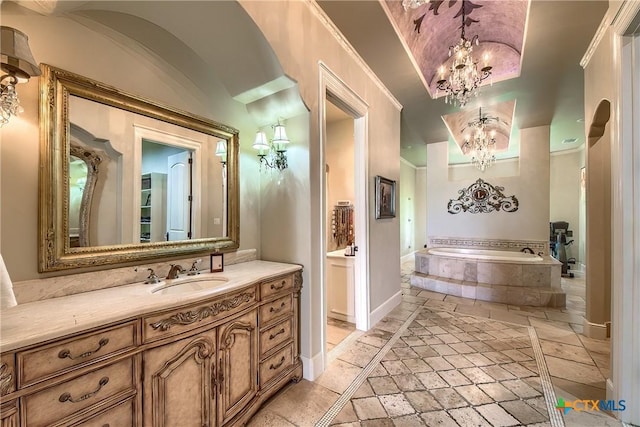 bathroom featuring vanity, baseboards, a bath, an inviting chandelier, and crown molding