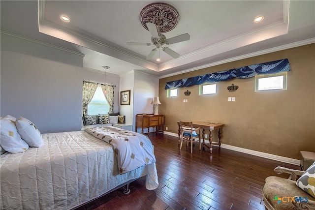 bedroom featuring dark wood-style floors, a tray ceiling, and multiple windows