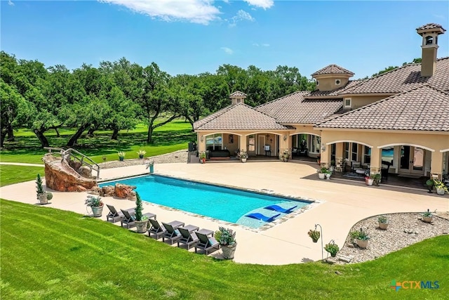 outdoor pool featuring a yard and a patio