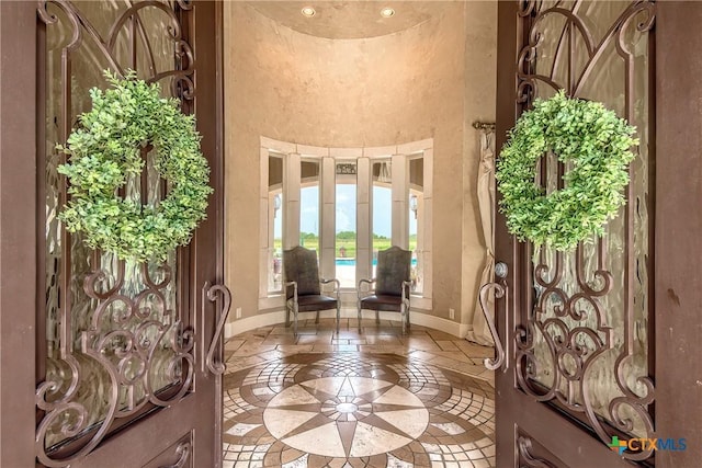 entryway featuring a high ceiling and baseboards