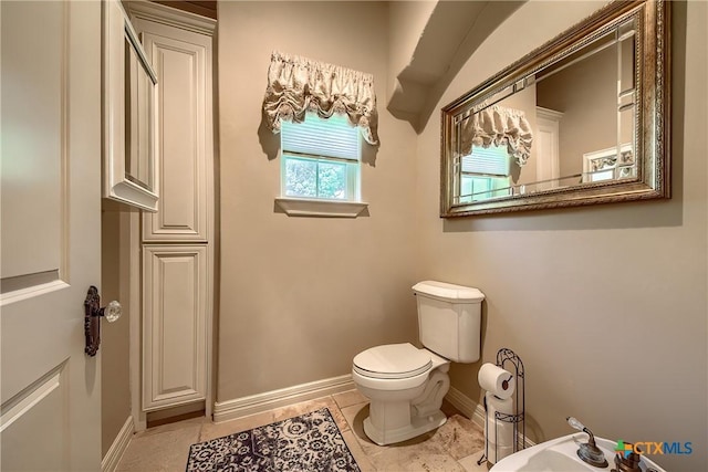 bathroom with tile patterned flooring, toilet, and baseboards