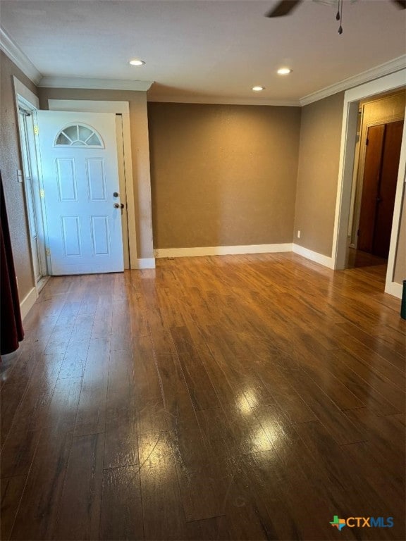 empty room featuring dark wood-type flooring, ceiling fan, and ornamental molding