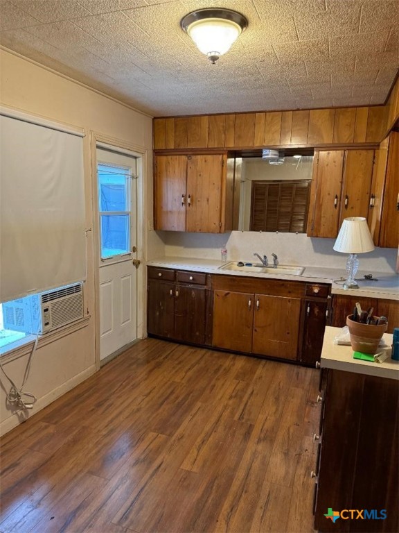 kitchen featuring dark hardwood / wood-style flooring, cooling unit, sink, and a textured ceiling