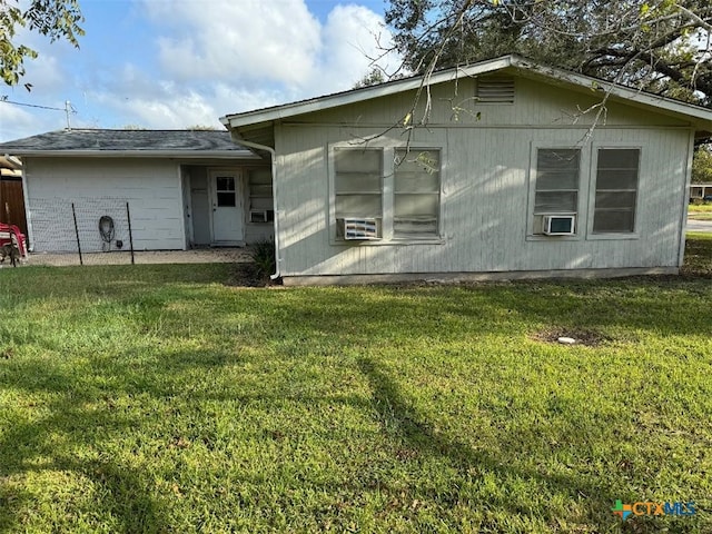 back of property featuring a lawn and cooling unit