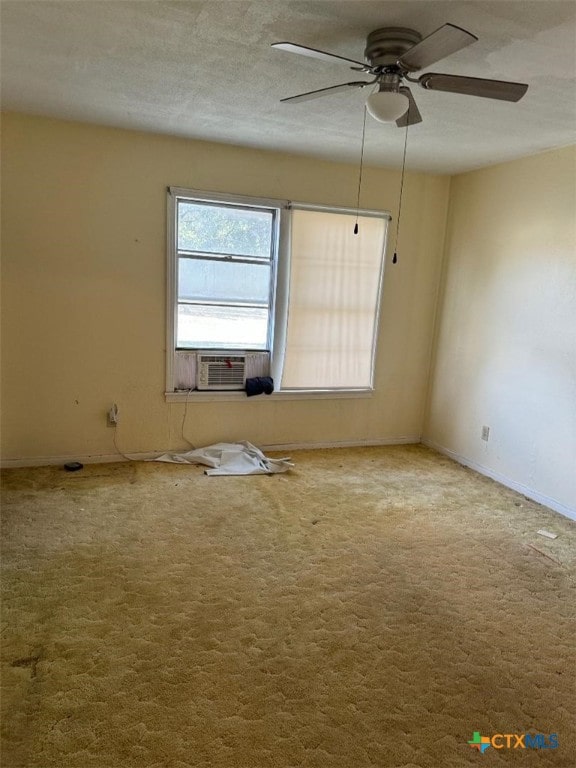 carpeted empty room featuring cooling unit, a textured ceiling, and ceiling fan