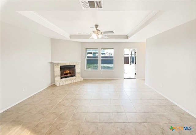 unfurnished living room with ornamental molding, ceiling fan, a raised ceiling, and light tile patterned floors