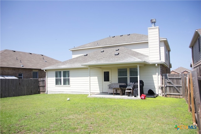 back of property featuring a patio area and a lawn