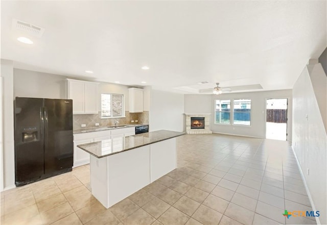 kitchen featuring black appliances, tasteful backsplash, light tile patterned flooring, dark stone counters, and white cabinets