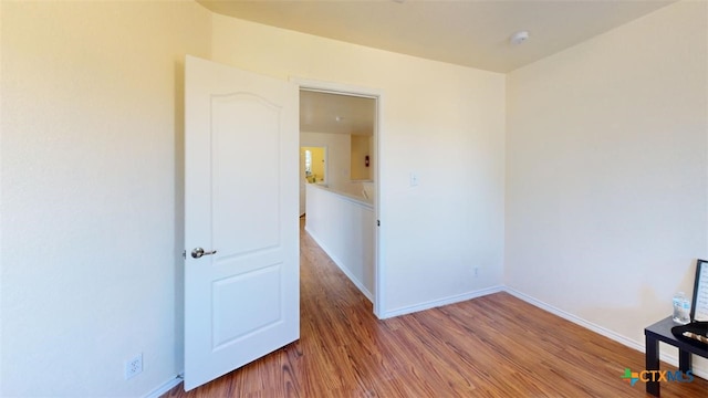 unfurnished room with wood-type flooring