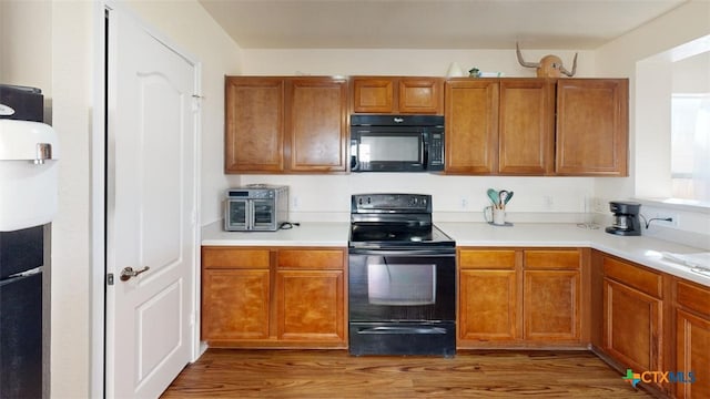 kitchen with black appliances and dark wood-type flooring