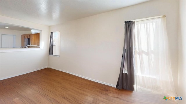 unfurnished room with wood-type flooring and a textured ceiling