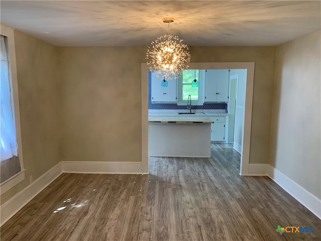 kitchen featuring sink, dark hardwood / wood-style floors, decorative light fixtures, a chandelier, and decorative backsplash