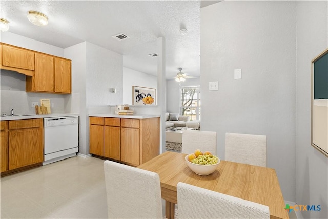 kitchen featuring visible vents, dishwasher, ceiling fan, light countertops, and a textured ceiling