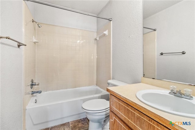 full bath featuring a textured wall, vanity, bathtub / shower combination, and toilet