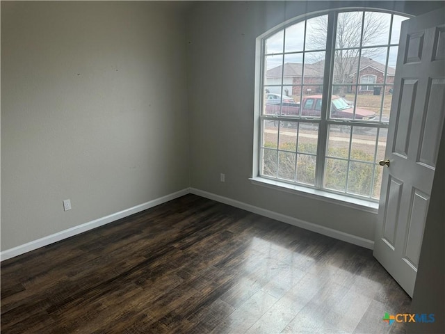 empty room with dark hardwood / wood-style flooring