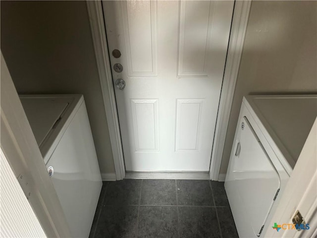 washroom featuring dark tile patterned floors and washing machine and clothes dryer