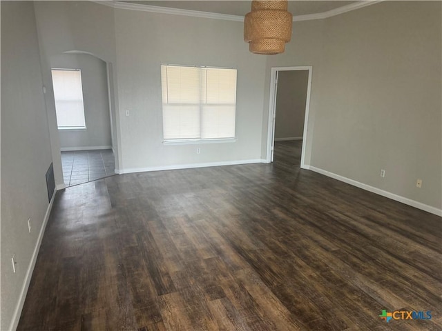 spare room featuring crown molding, plenty of natural light, and dark hardwood / wood-style floors