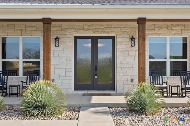 200 County Road 246, Florence, TX 76527 - doorway to property featuring french doors, stone siding, a shingled roof, and a porch
