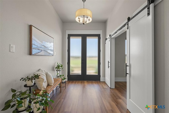 200 County Road 246, Florence, TX 76527 - entrance foyer featuring french doors, a barn door, wood finished floors, a chandelier, and baseboards