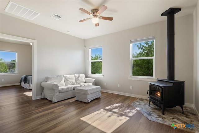 200 County Road 246, Florence, TX 76527 - living room featuring a wood stove, baseboards, wood finished floors, and ceiling fan