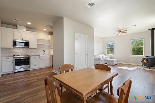 200 County Road 246, Florence, TX 76527 - dining area with a wood stove, dark wood finished floors, ceiling fan, baseboards, and recessed lighting