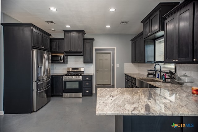 kitchen featuring stainless steel appliances, sink, kitchen peninsula, tasteful backsplash, and light stone countertops