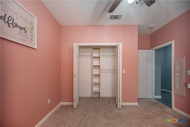 unfurnished bedroom featuring a closet, light carpet, and ceiling fan