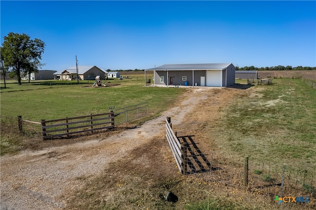 view of yard with a garage and a rural view