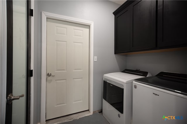 clothes washing area with cabinets and separate washer and dryer