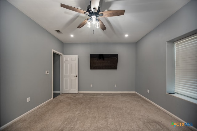 carpeted spare room with ceiling fan