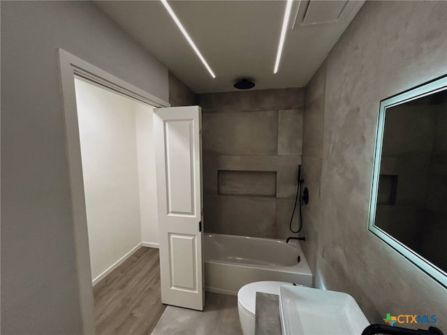 bathroom with wood finished floors, a combined bath / shower with rainfall shower, and toilet