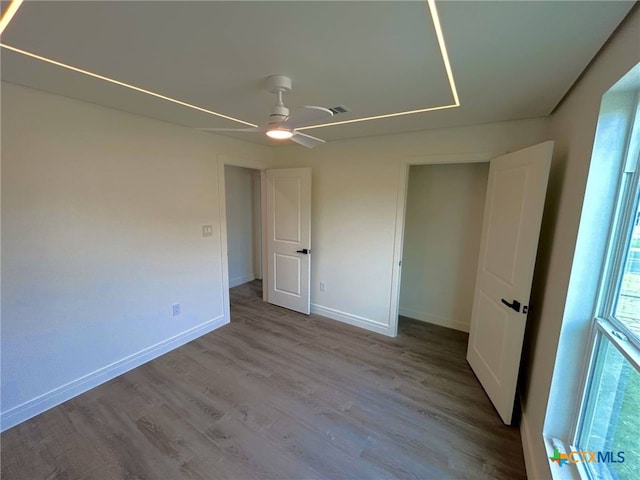 unfurnished bedroom featuring baseboards, a ceiling fan, and wood finished floors