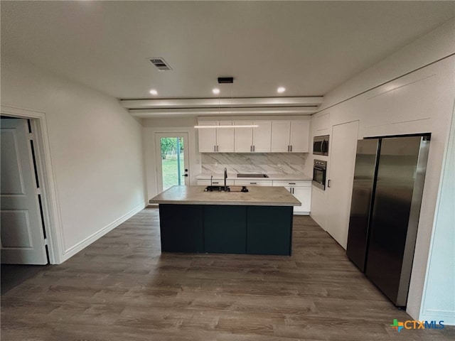 kitchen featuring stainless steel appliances, visible vents, white cabinetry, light countertops, and dark wood-type flooring