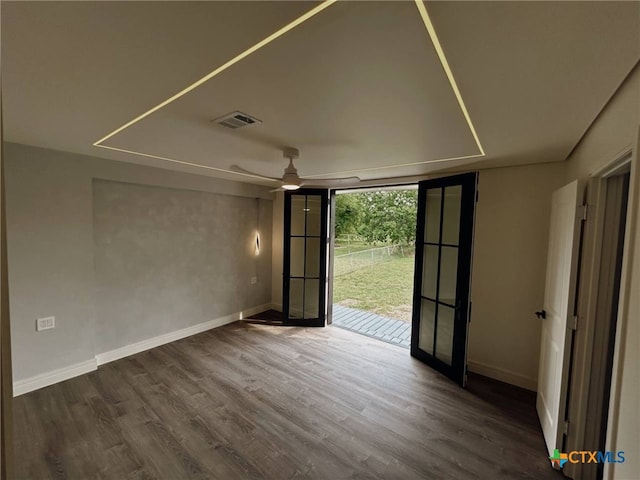 unfurnished room featuring visible vents, wood finished floors, baseboards, and a ceiling fan