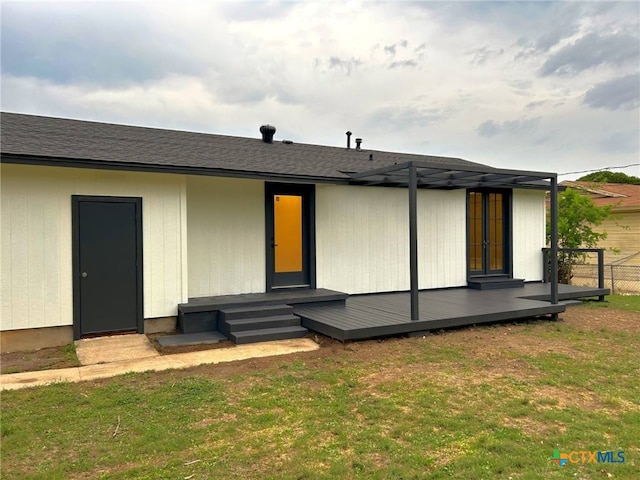 rear view of house with fence and a lawn