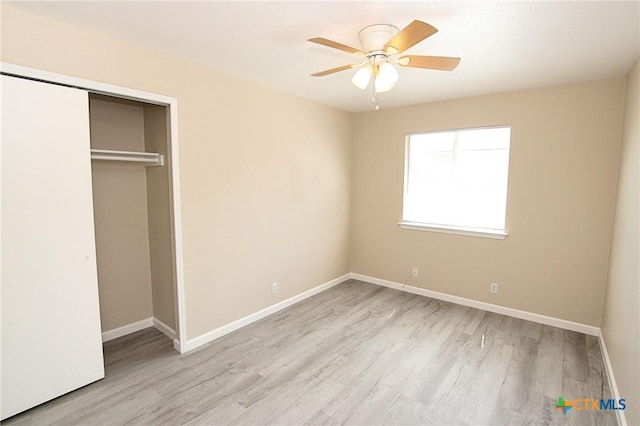 unfurnished bedroom with a closet, baseboards, a ceiling fan, and wood finished floors
