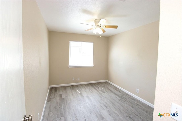 unfurnished room with baseboards, a ceiling fan, and wood finished floors