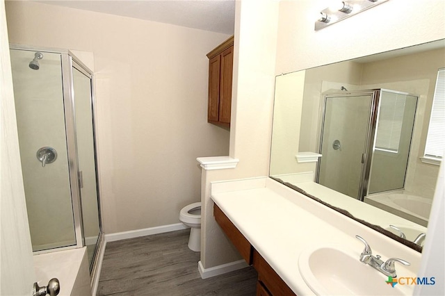 full bathroom with toilet, baseboards, a stall shower, and wood finished floors