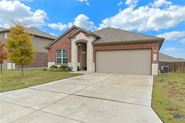 view of front of property with a garage, a front yard, and central AC