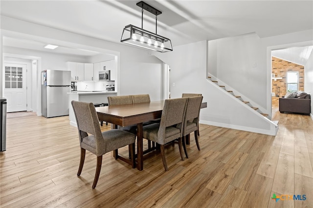 151 Crest Circle Dr, San Marcos, TX 78666 - dining space featuring stairs, light wood-style floors, and baseboards
