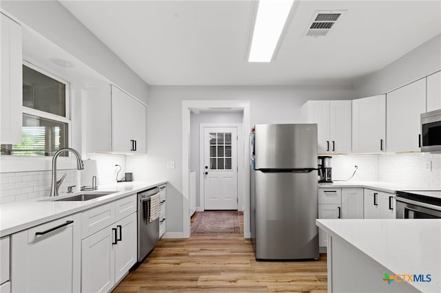 151 Crest Circle Dr, San Marcos, TX 78666 - kitchen with appliances with stainless steel finishes, a sink, tasteful backsplash, light countertops, and white cabinetry