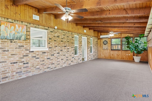 151 Crest Circle Dr, San Marcos, TX 78666 - carpeted spare room with wooden ceiling with exposed beams, ceiling fan, wooden walls, a wall unit AC, and brick wall