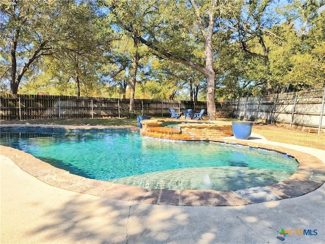 view of swimming pool featuring pool water feature and an in ground hot tub