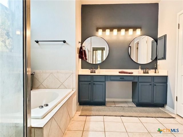 bathroom featuring tile patterned floors, a relaxing tiled tub, and vanity