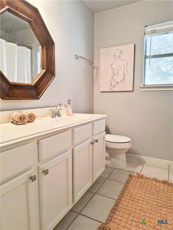 bathroom featuring tile patterned floors, vanity, and toilet